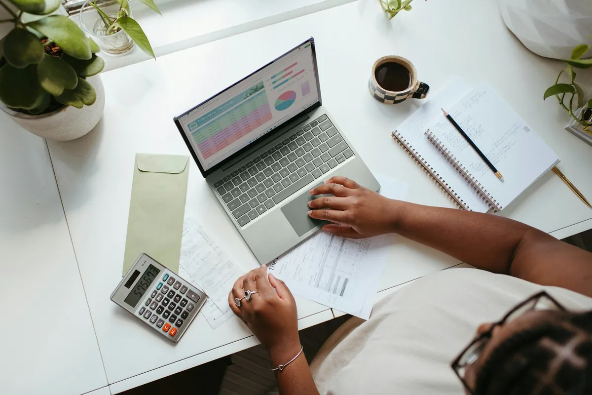 An accountant at a desk with a laptop chart, a calculator and receipts
