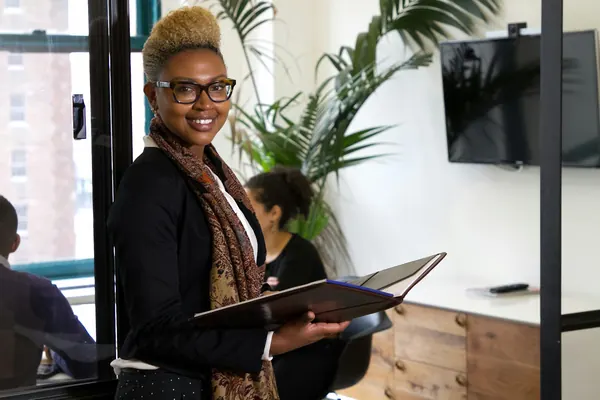 An office administrator holding an open binder in an office