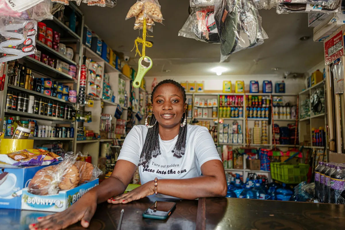 A shop attendant behind the counter of a small shop
