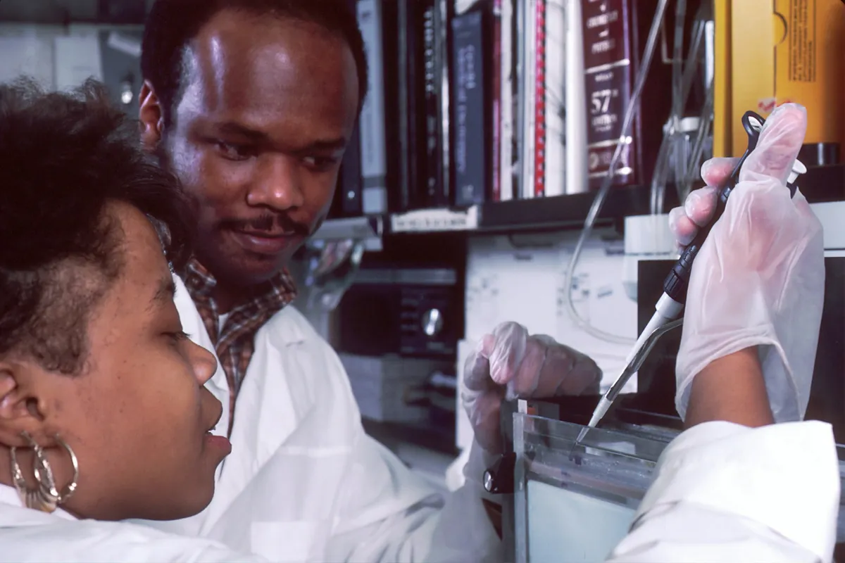 Two laboratory staff working with a pipette