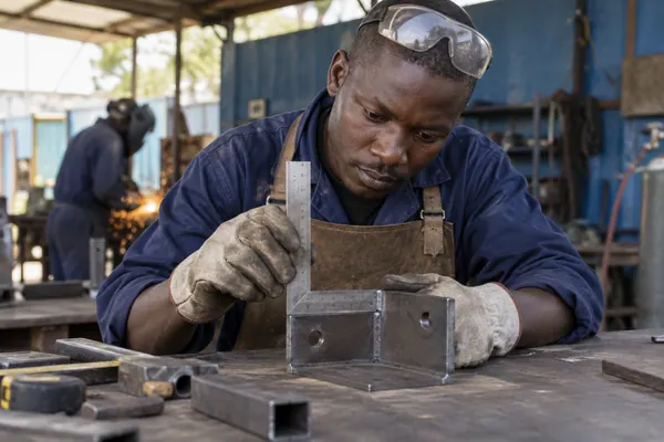 Metalworker measuring a steel component