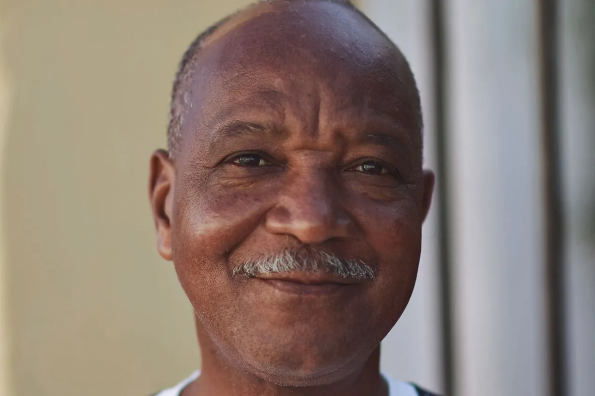 An older Kenyan man smiling in warm light