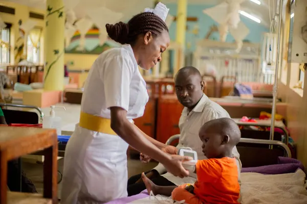 A nurse caring for a young child in a hospital ward