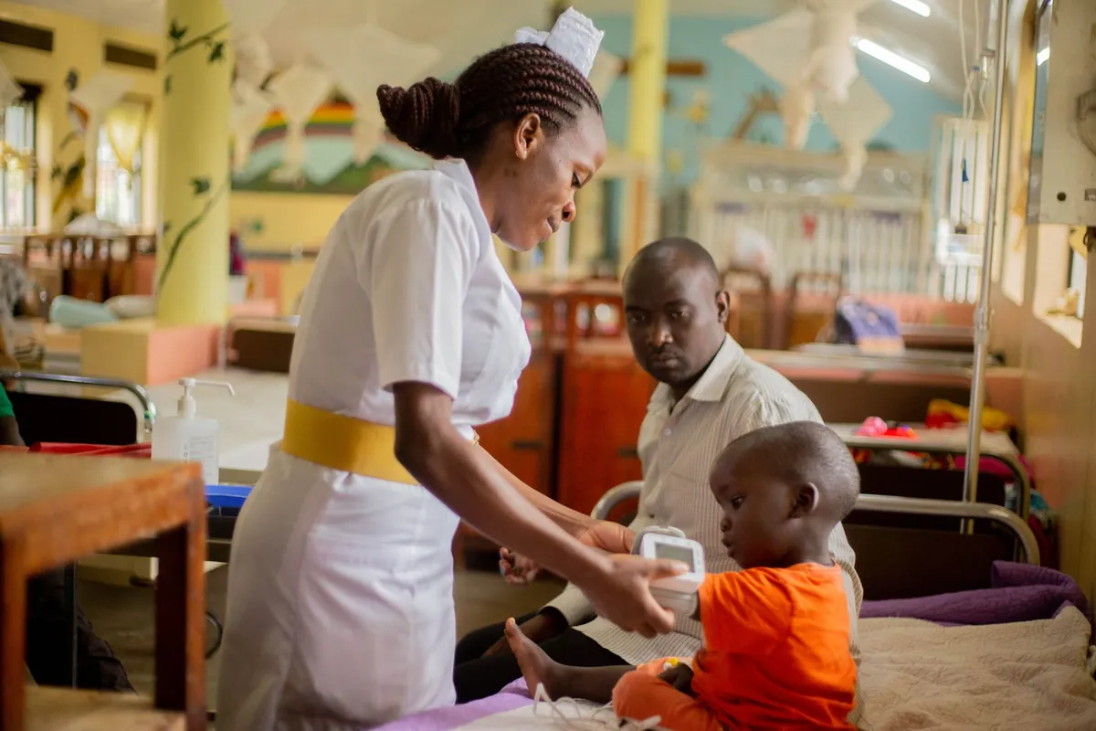 A nurse caring for a young child in a hospital ward