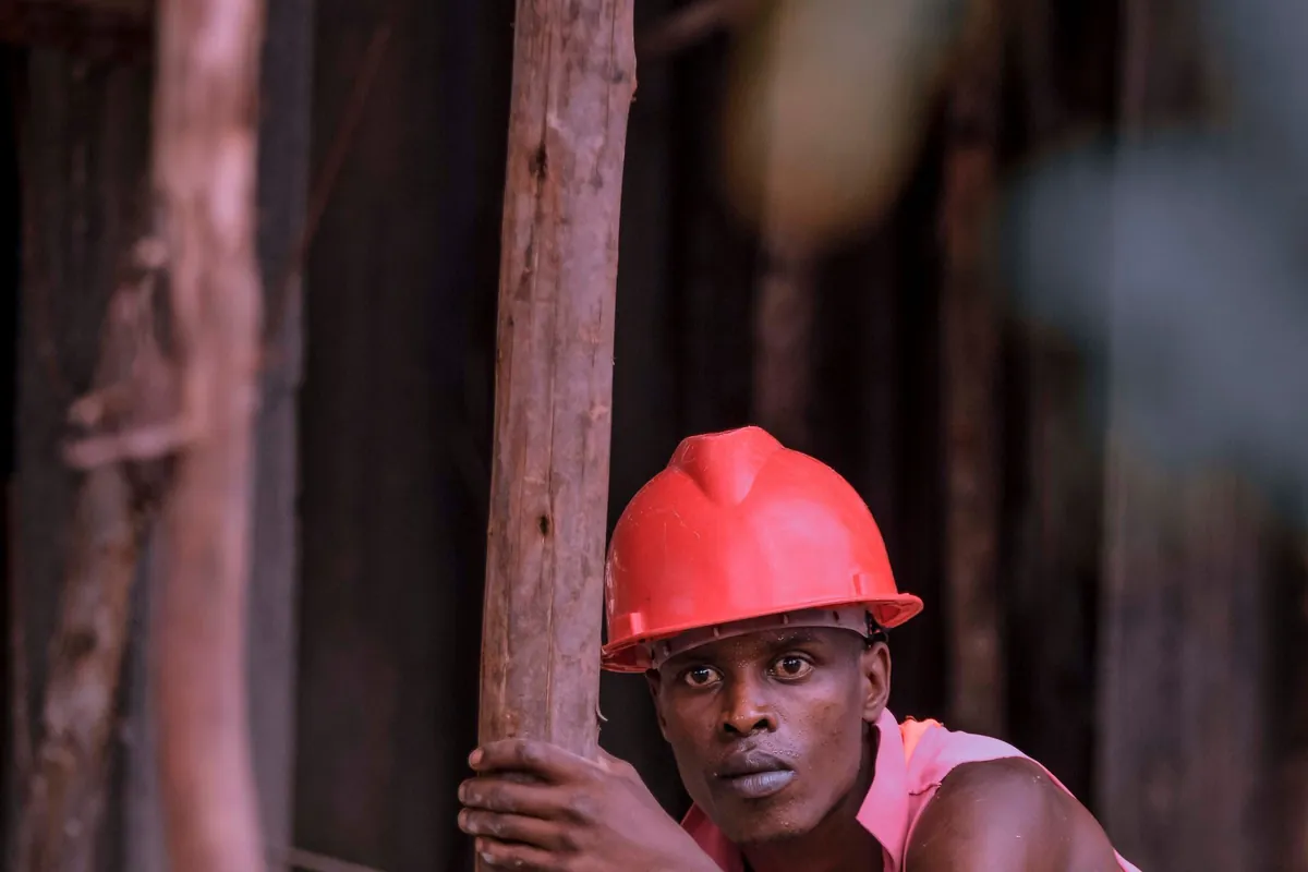 A construction worker in a red safety helmet on a building site