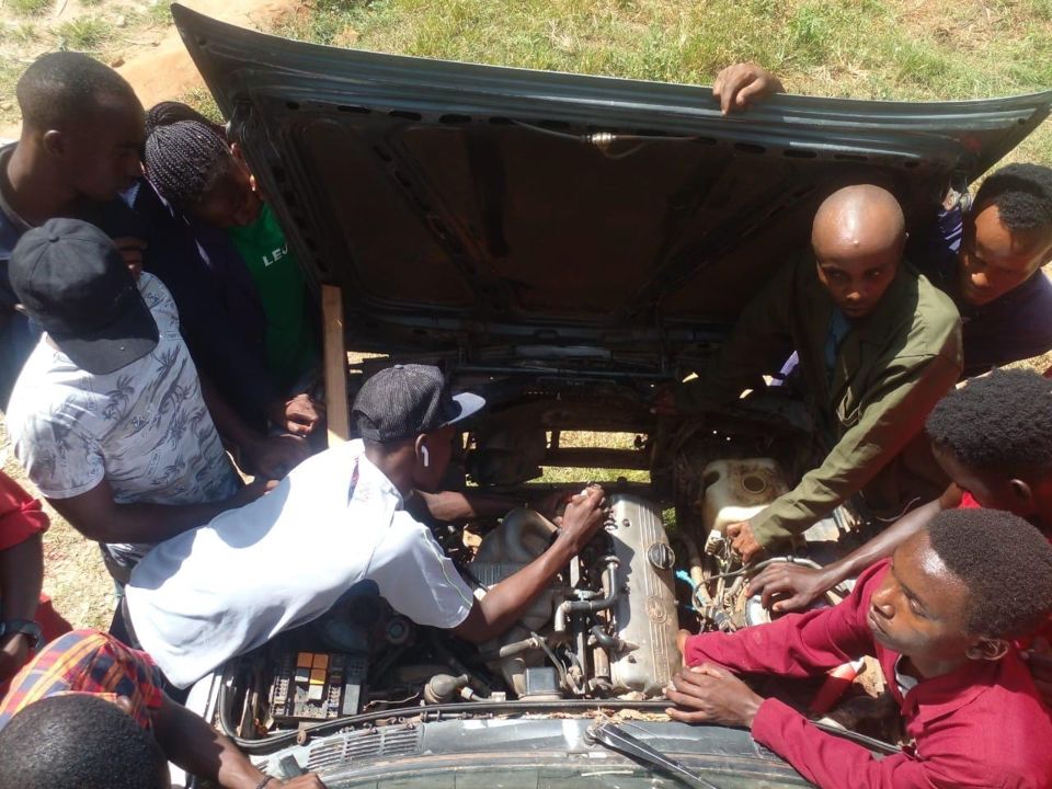Trainees working on a car engine during an automotive practical class