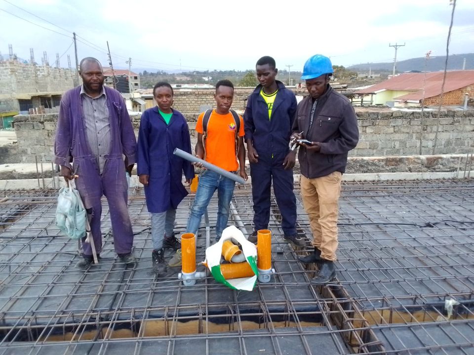 Building and civil engineering trainees with their trainer on a construction site