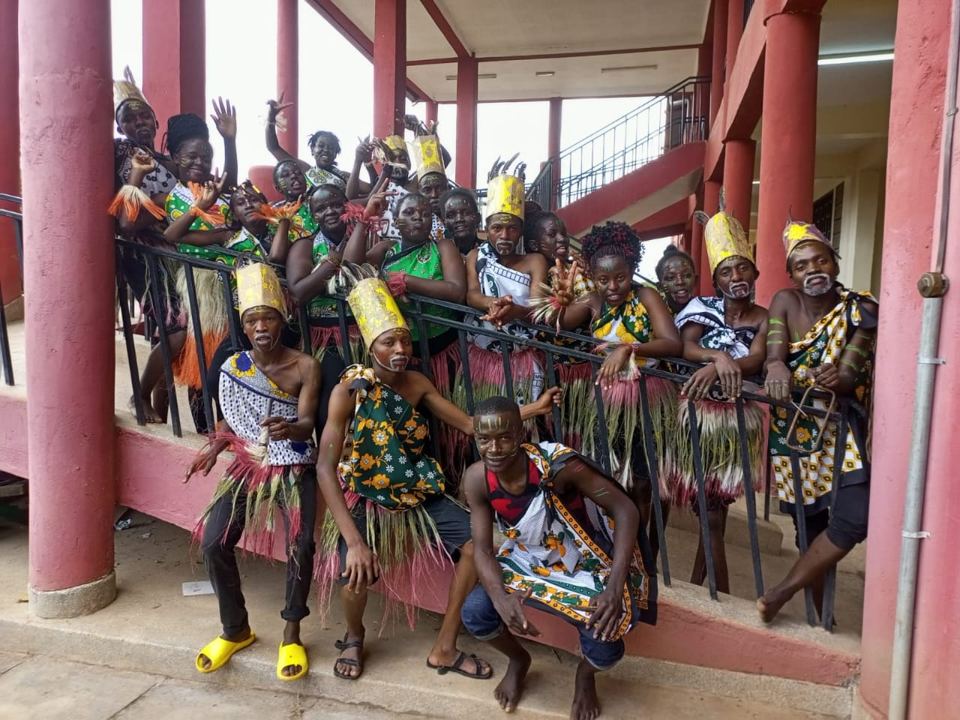 Mwala TVC trainees in traditional dress on the steps of a college building